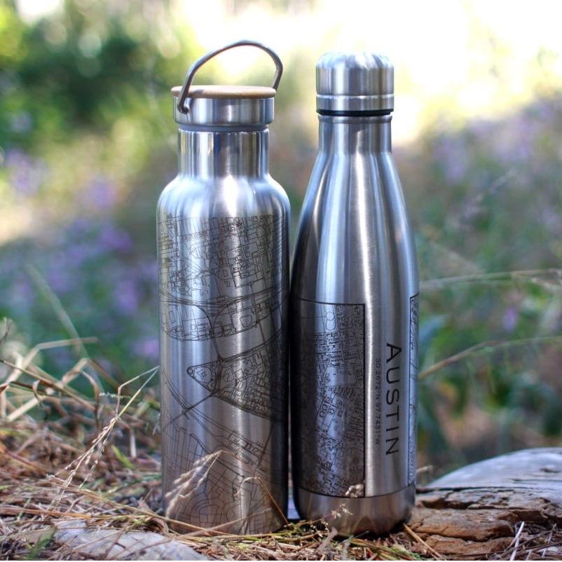 A 17oz insulated stainless steel bottle featuring a custom engraved map of Glacier National Park, Alaska, showcasing its stunning topography.