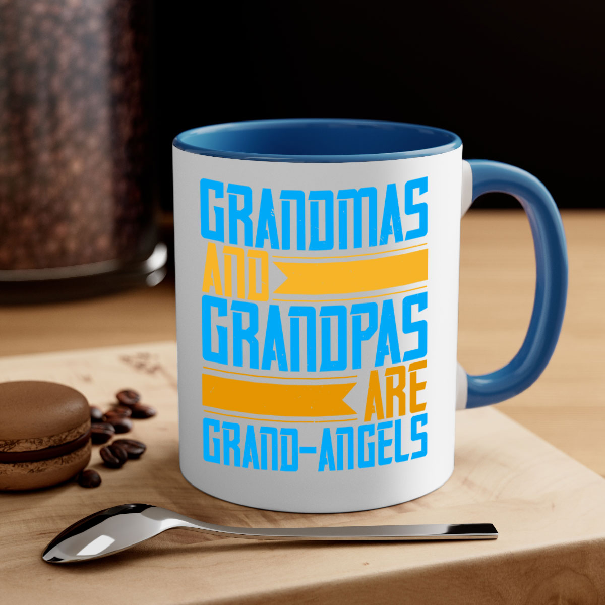 A two-tone ceramic coffee mug with a colored handle and interior, featuring the text 'Grandmas and grandpas are grandangels' in a stylish font.