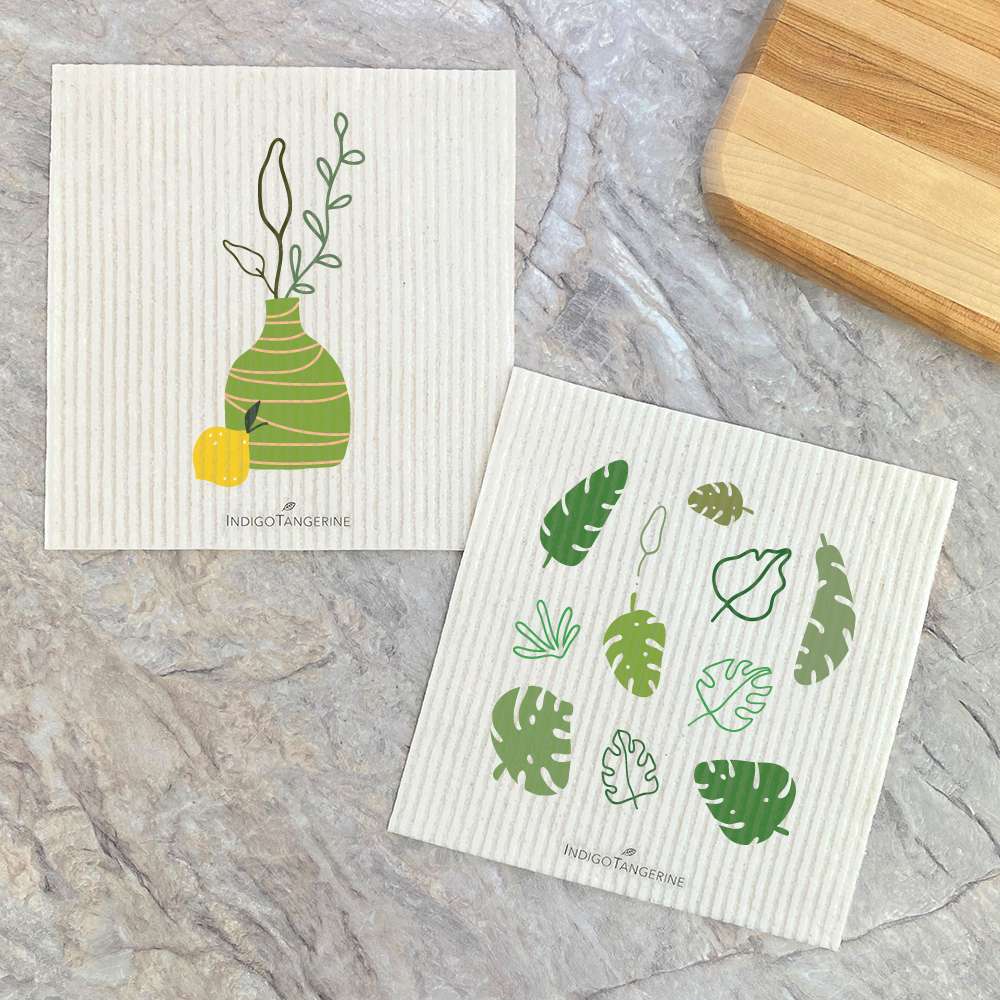 Two eco-friendly Swedish dish cloths featuring Monstera palm leaves design, showcasing vibrant colors and plant-based materials.