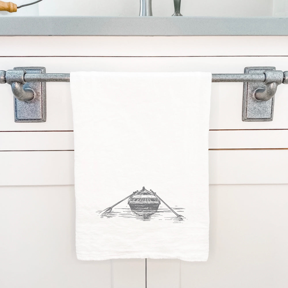 A beautifully designed cotton tea towel featuring a hand-drawn rowboat on water, showcasing vibrant colors and hemmed edges.