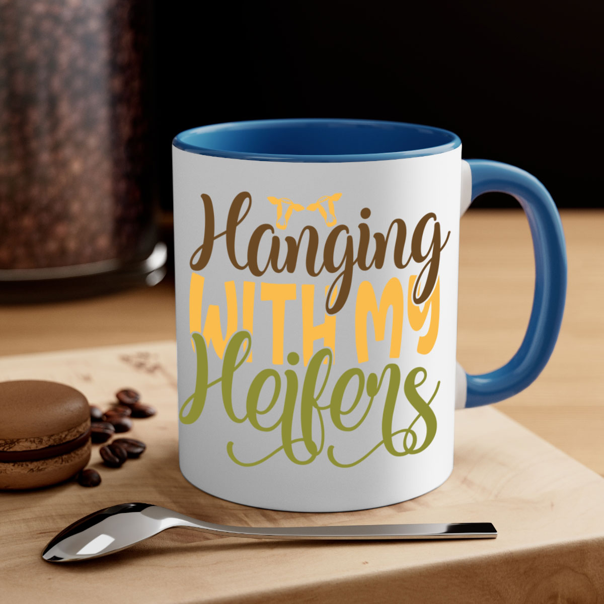 A two-tone ceramic mug with a colorful handle and interior, featuring the phrase 'Hanging with My Heifers' in a glossy finish.