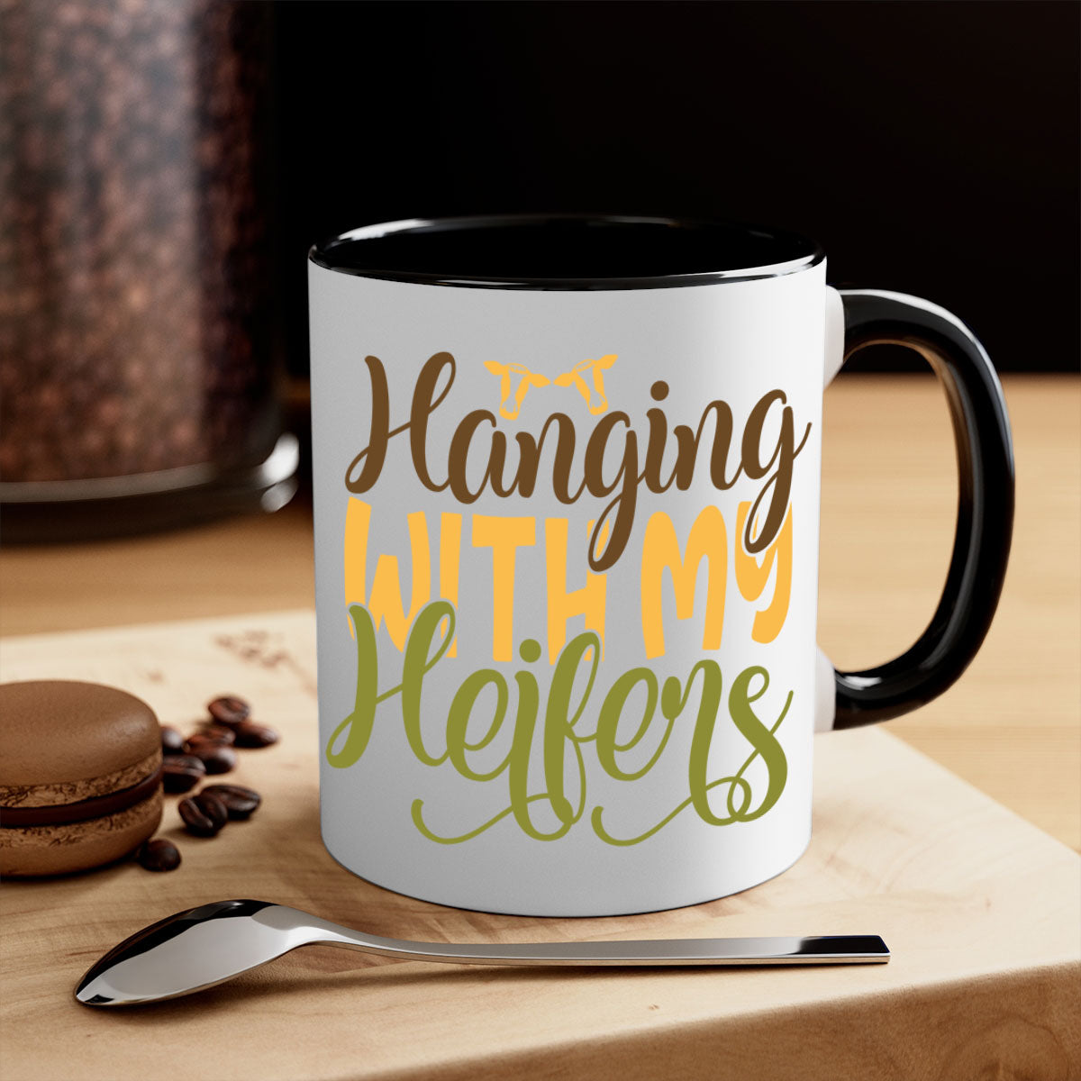 A two-tone ceramic mug with a colorful handle and interior, featuring the phrase 'Hanging with My Heifers' in a glossy finish.
