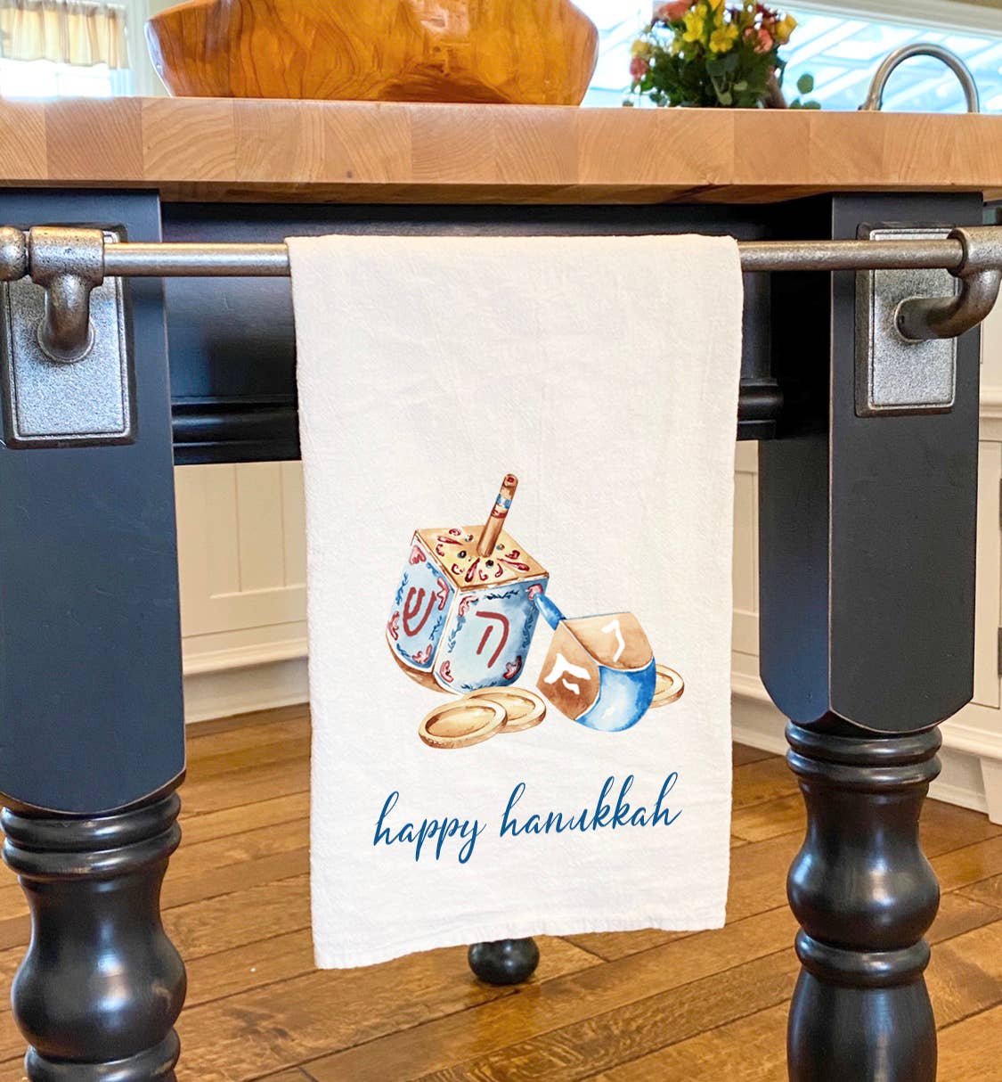 Cotton tea towel featuring a colorful dreidel and coins design for Hanukkah celebrations.