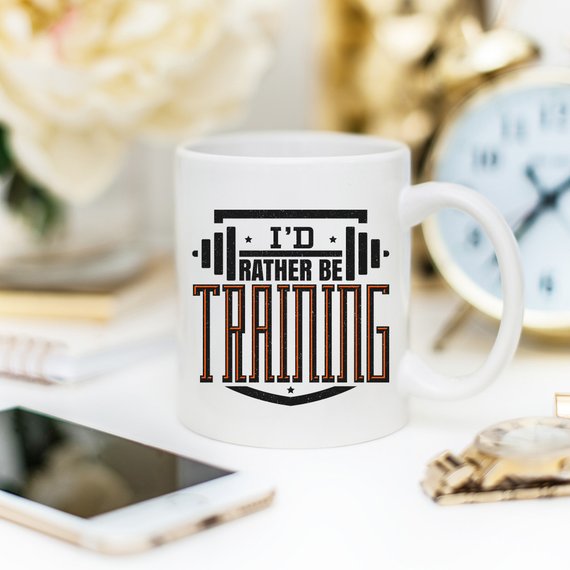 A humorous 'I'd Rather Be Training' coffee mug, showcasing a fun design perfect for fitness enthusiasts, crafted from high-quality ceramic.