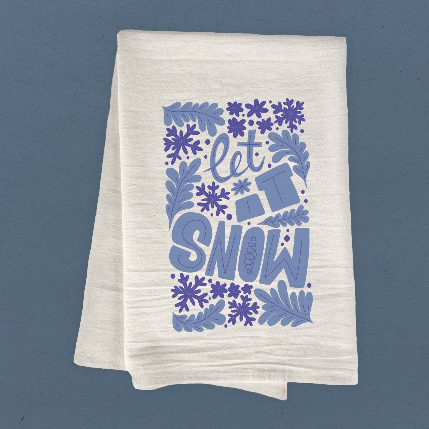 Let it Snow cotton tea towel featuring a festive winter design, made from 100% absorbent cotton with hemmed edges.