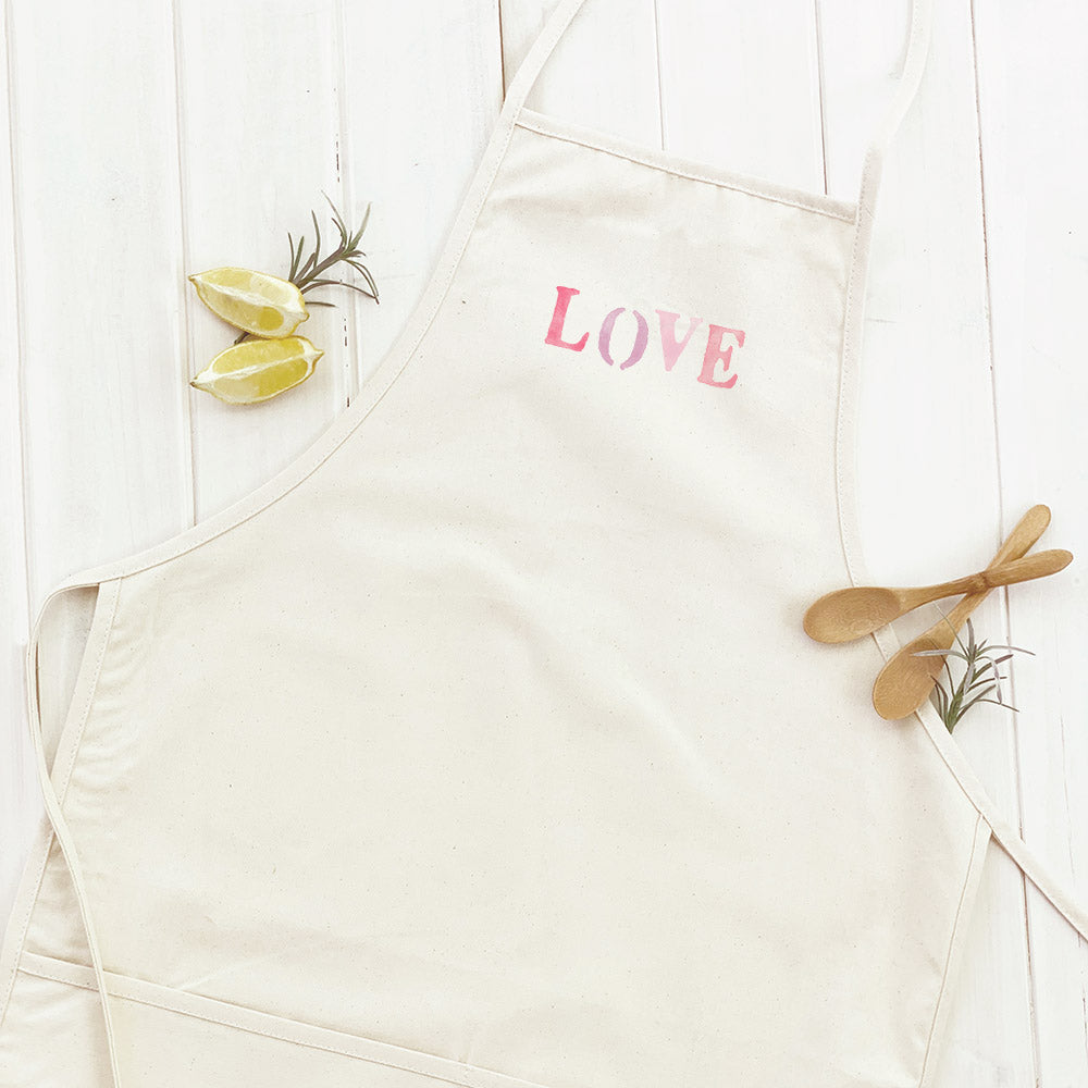 Love Stencil Women's Apron featuring elegant design, adjustable neck, and divided front pocket, made from durable cotton canvas.