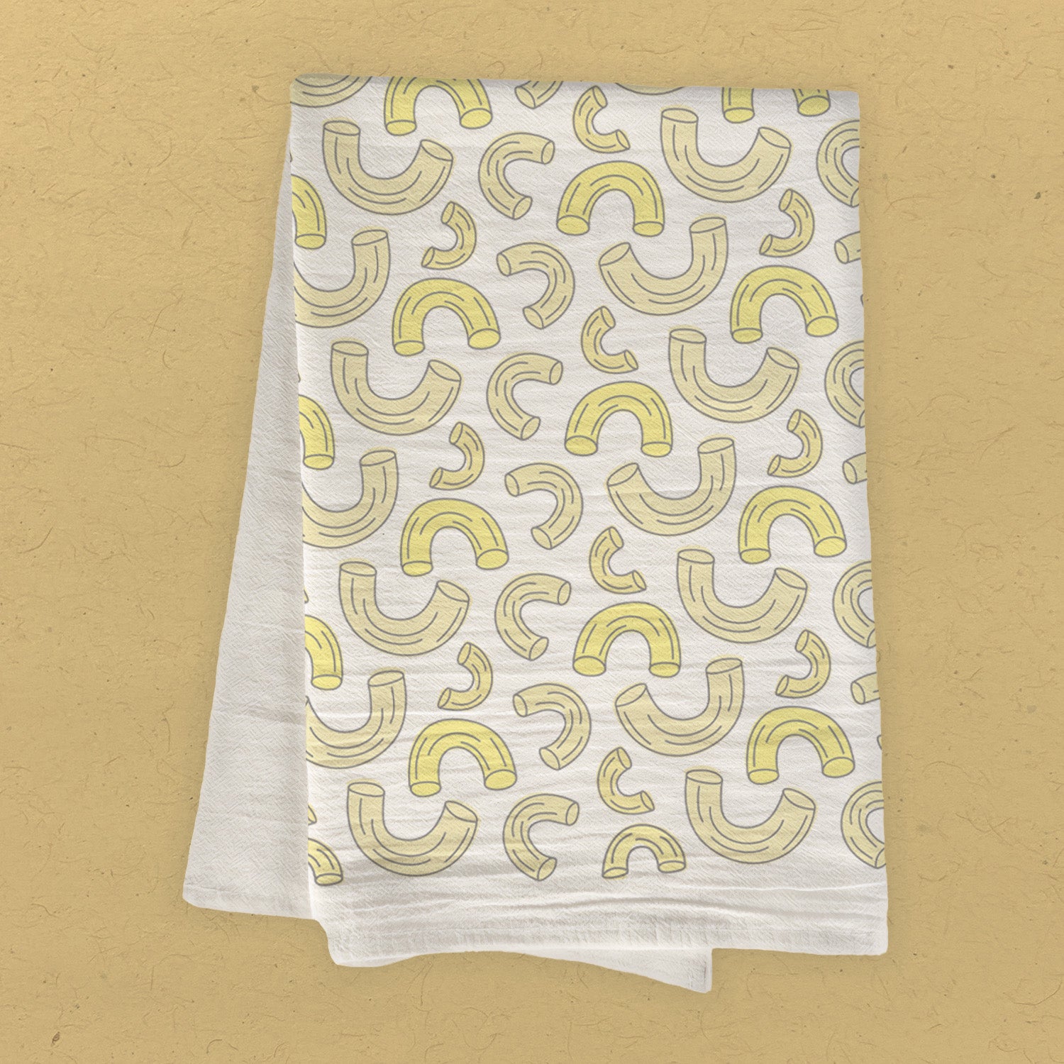 A vibrant cotton tea towel featuring a macaroni pattern, showcasing its absorbent fabric and hemmed edges, perfect for kitchen use.