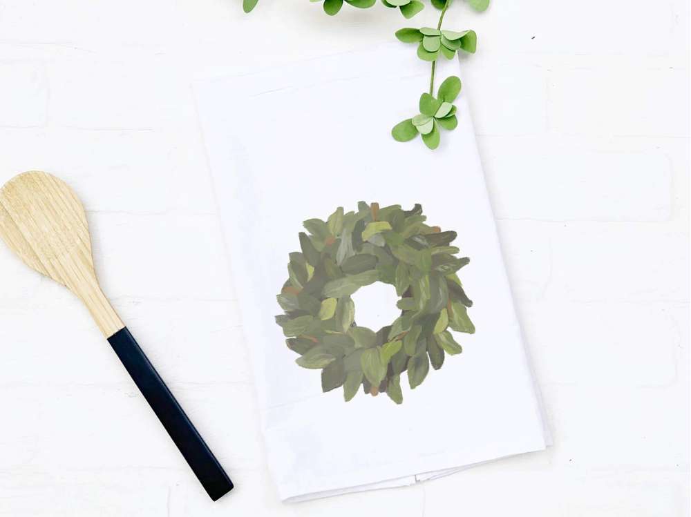 Magnolia Wreath cotton tea towel featuring a vibrant floral design, perfect for kitchen use and decorative purposes.