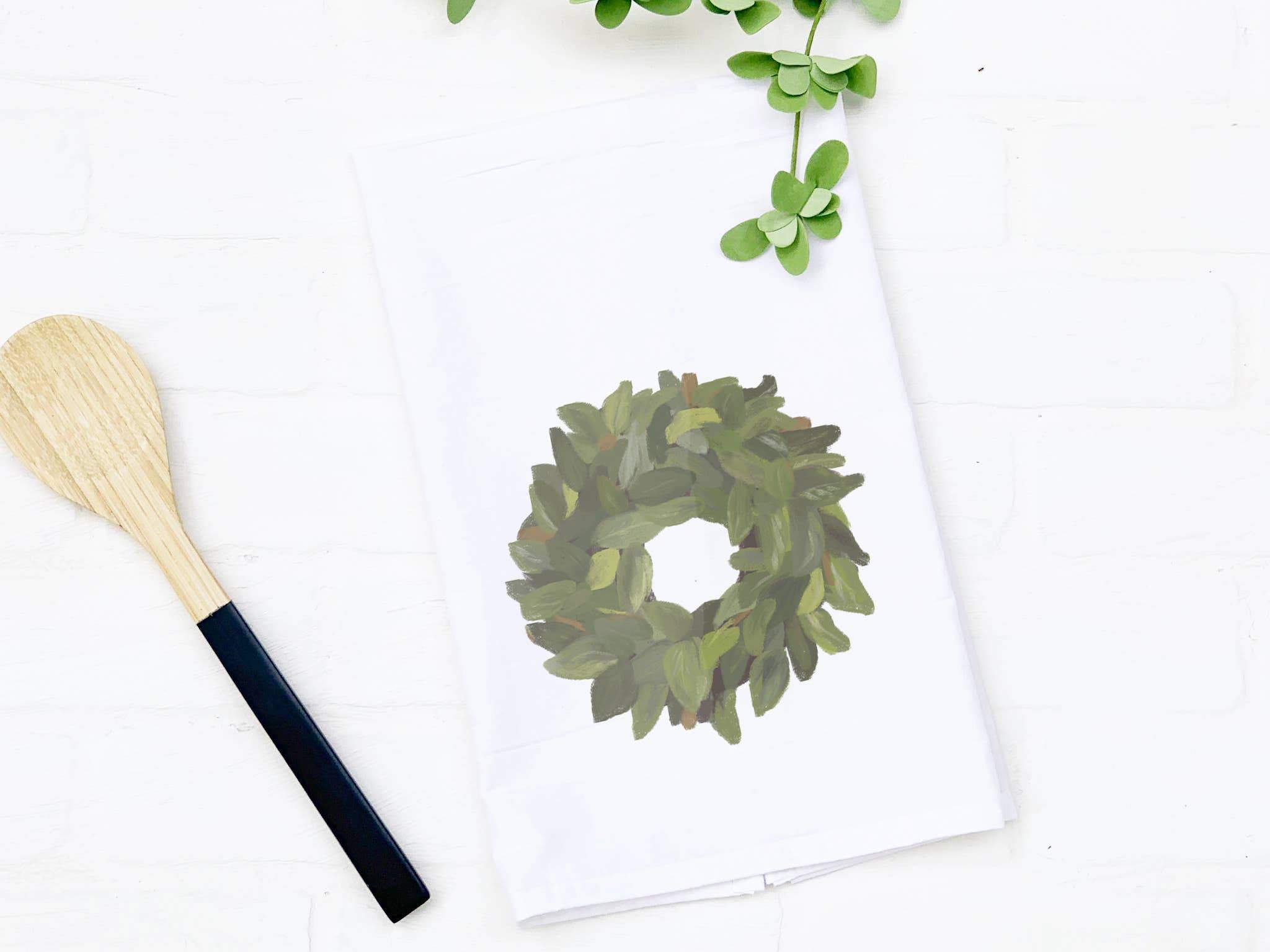 Magnolia Wreath cotton tea towel featuring a vibrant floral design, perfect for kitchen use and decorative purposes.