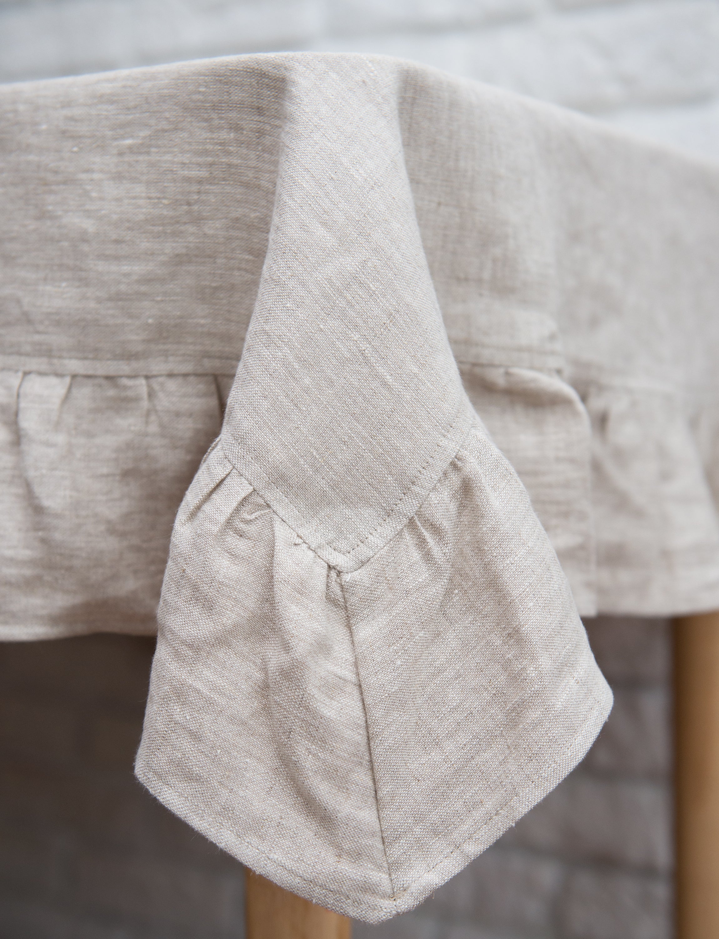 Natural Light linen tablecloth with elegant ruffles, showcasing high-quality European linen in a soft, inviting color.