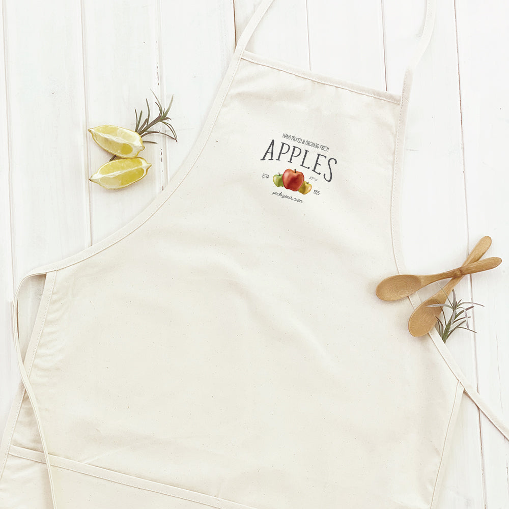 Orchard Fresh Apples Women's Apron featuring a vibrant apple print, adjustable neck, and divided front pocket, made from durable cotton canvas.