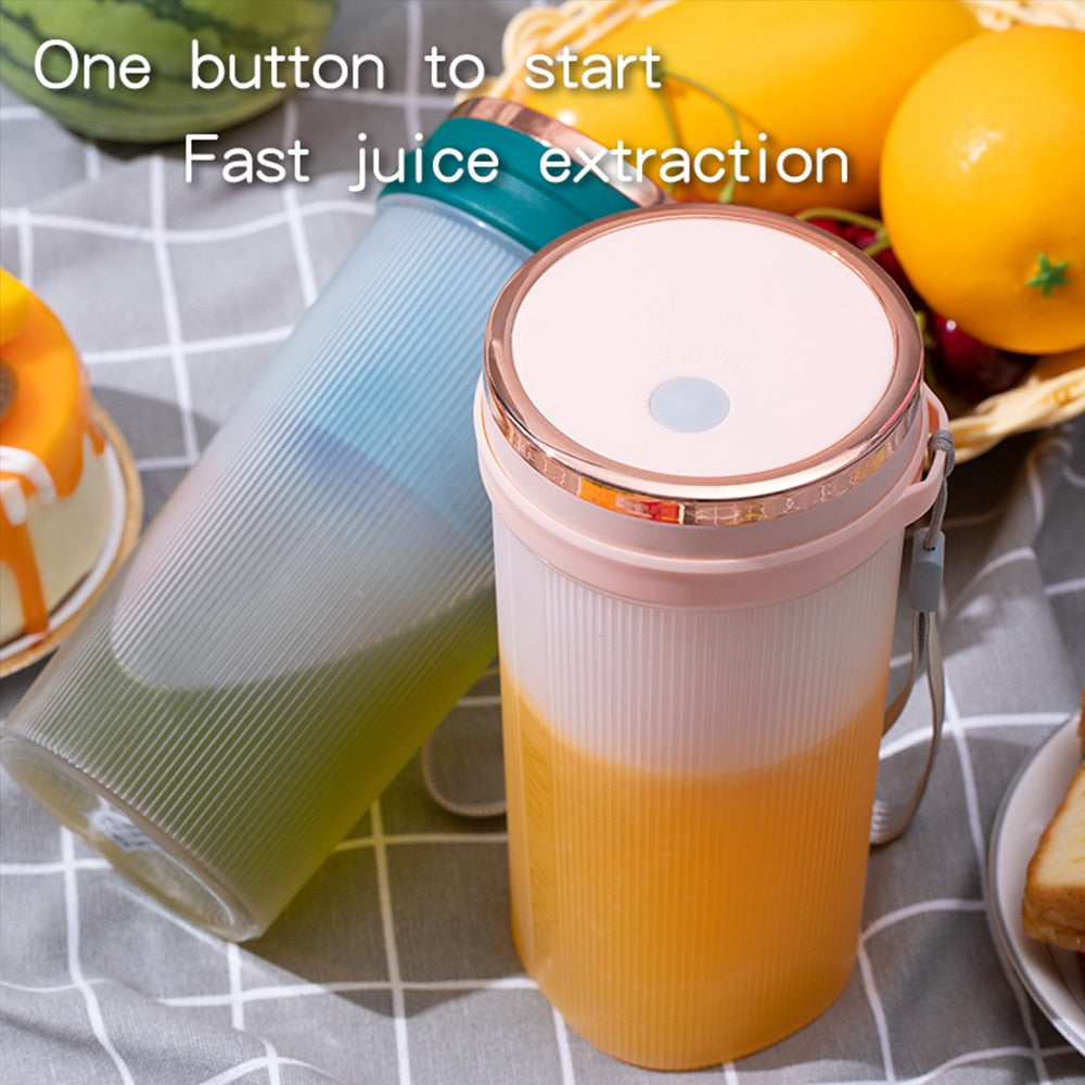 Portable Juicer Cup in green and pink colors with USB charging cable, showcasing its compact design and 6-leaf blade.