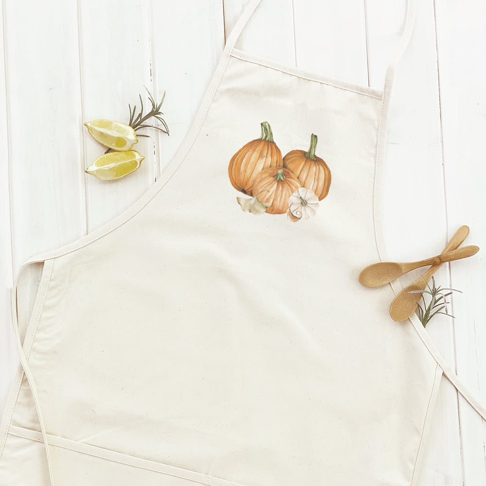 Pumpkin Harvest Women's Apron featuring a vibrant pumpkin design, adjustable neck, and divided front pocket, made from durable cotton canvas.