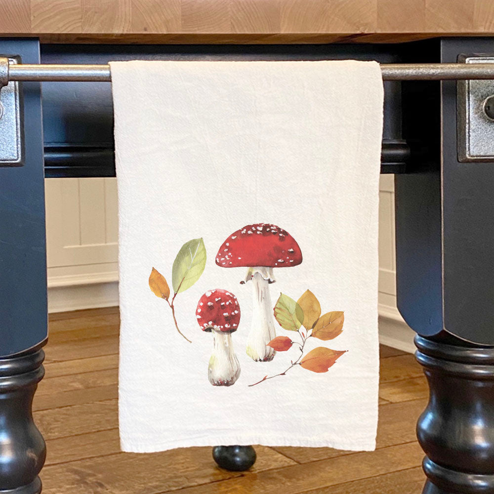 A vibrant cotton tea towel featuring a red capped mushroom design, perfect for kitchen use and decor.