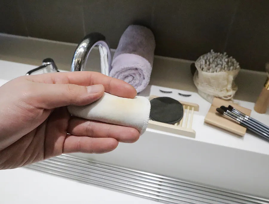 Reusable cotton rounds made from bamboo charcoal, displayed in an organic mesh bag, showcasing their eco-friendly design.