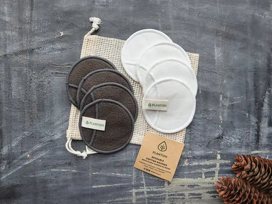 Reusable cotton rounds made from bamboo charcoal, displayed in an organic mesh bag, showcasing their eco-friendly design.