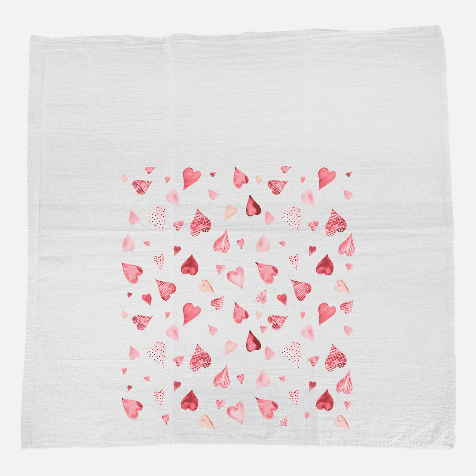 A vibrant cotton tea towel featuring a scattered hearts pattern, perfect for kitchen use.