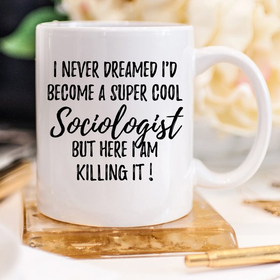 A white ceramic mug featuring a vibrant sociologist design printed on both sides, perfect for coffee or tea.