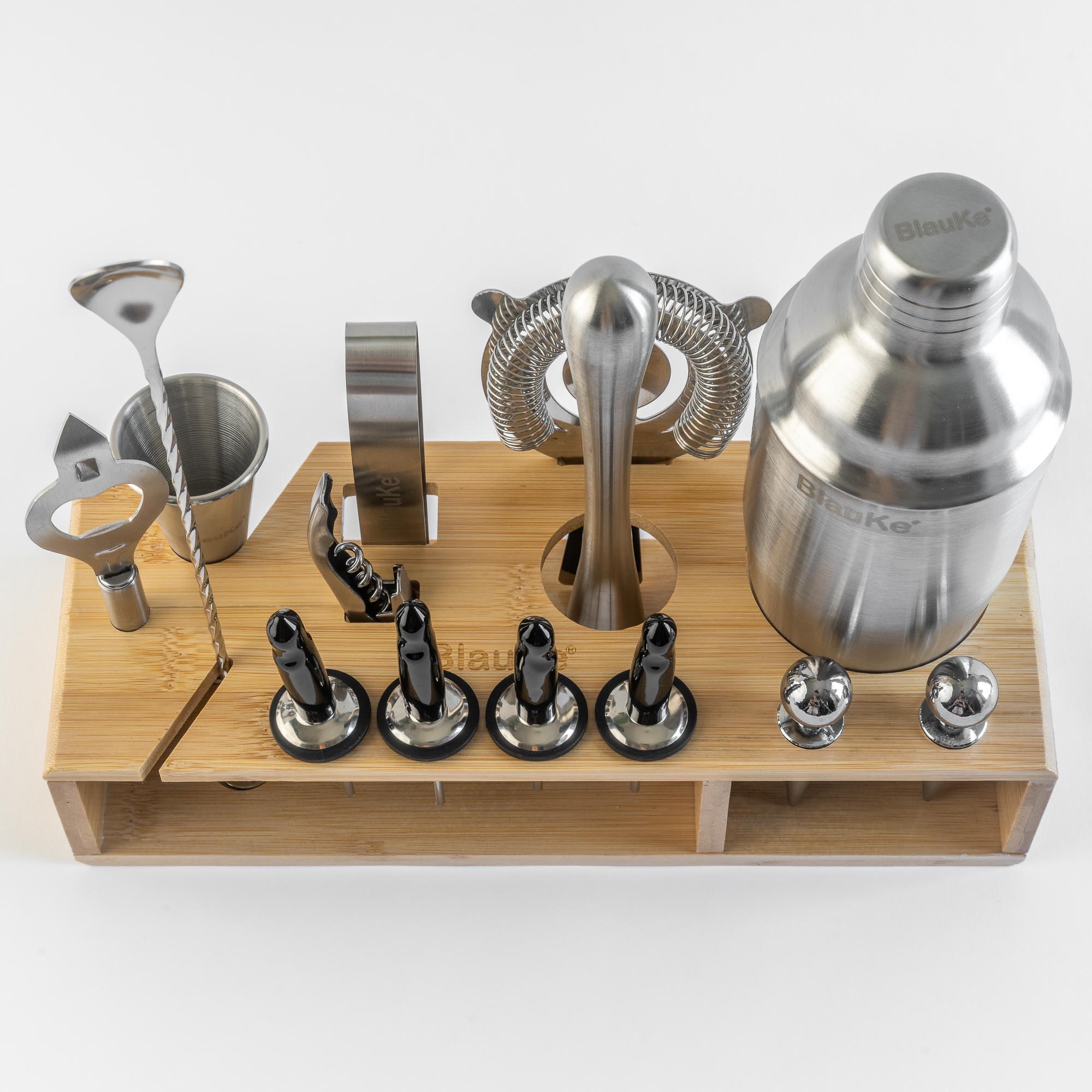 A complete 17-piece stainless steel cocktail shaker set displayed on an elegant bamboo stand, showcasing various bar tools including a shaker, jigger, and strainer.