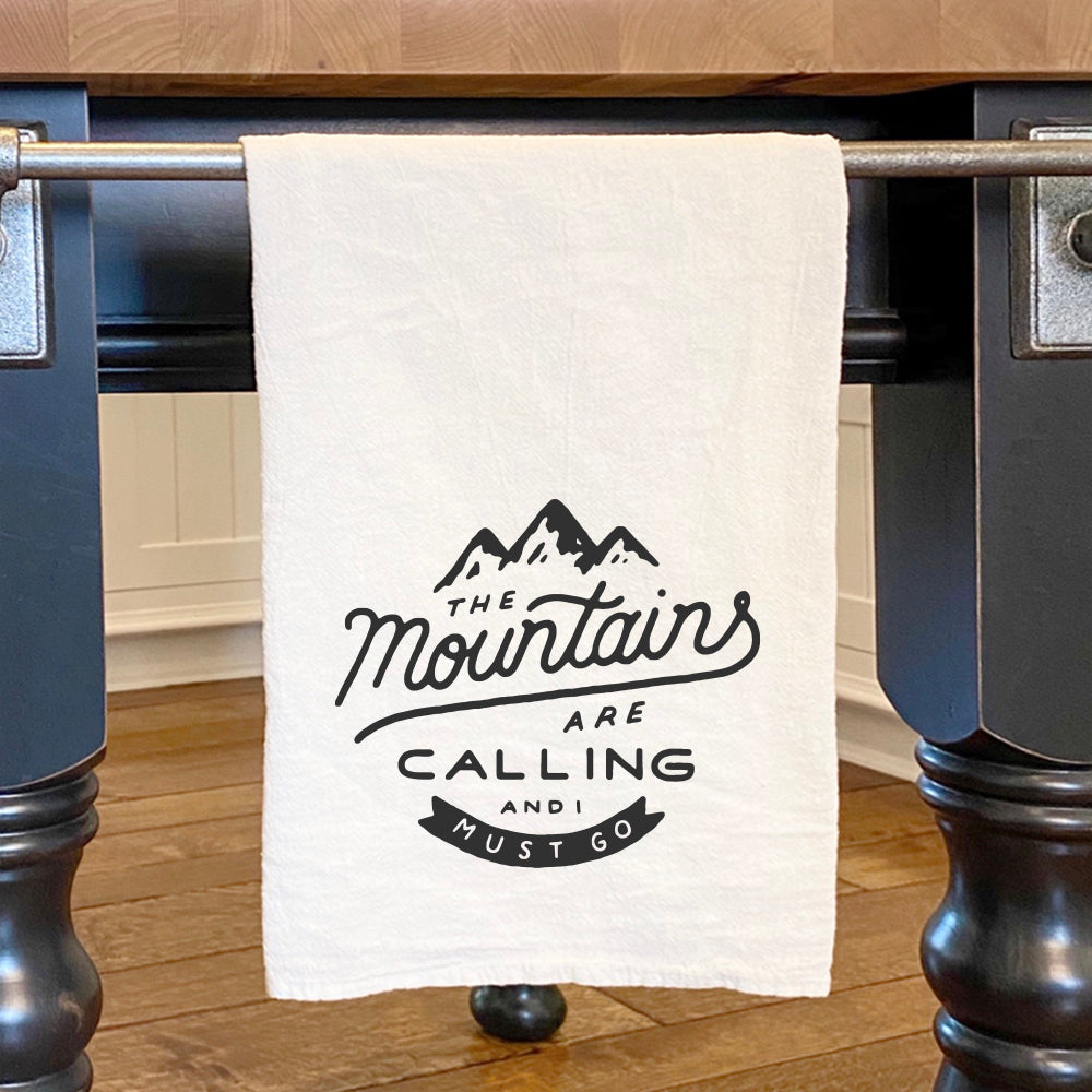 A vibrant cotton tea towel featuring a mountain design, perfect for kitchen use.