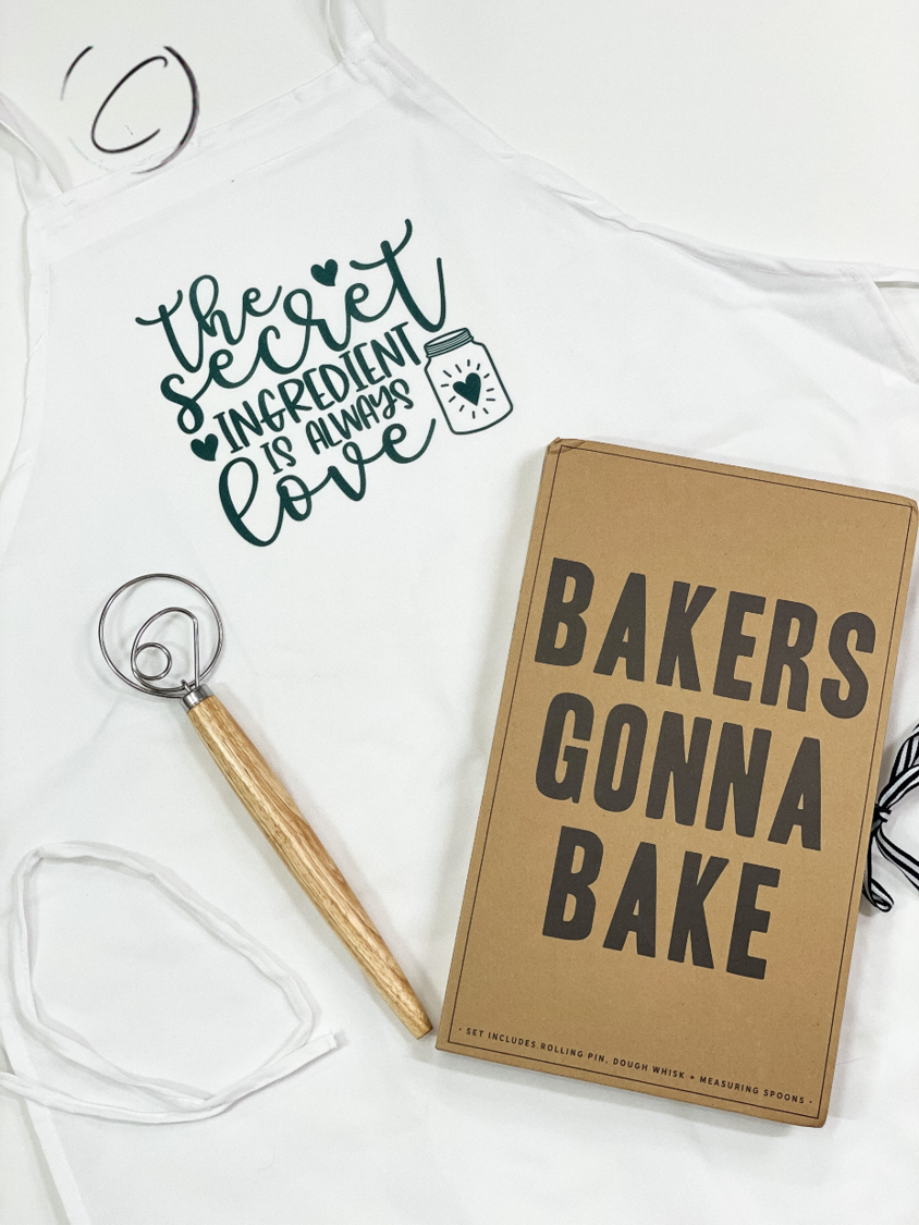 The Secret Ingredient Apron featuring a stylish design, made from 100% brushed filament polyester, with adjustable neck strap and long waist ties.