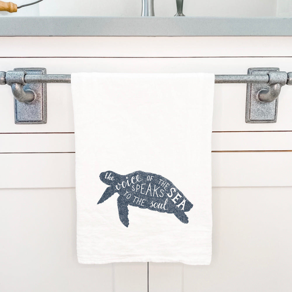 A vibrant cotton tea towel featuring a turtle design, showcasing its absorbent texture and flour sack style.