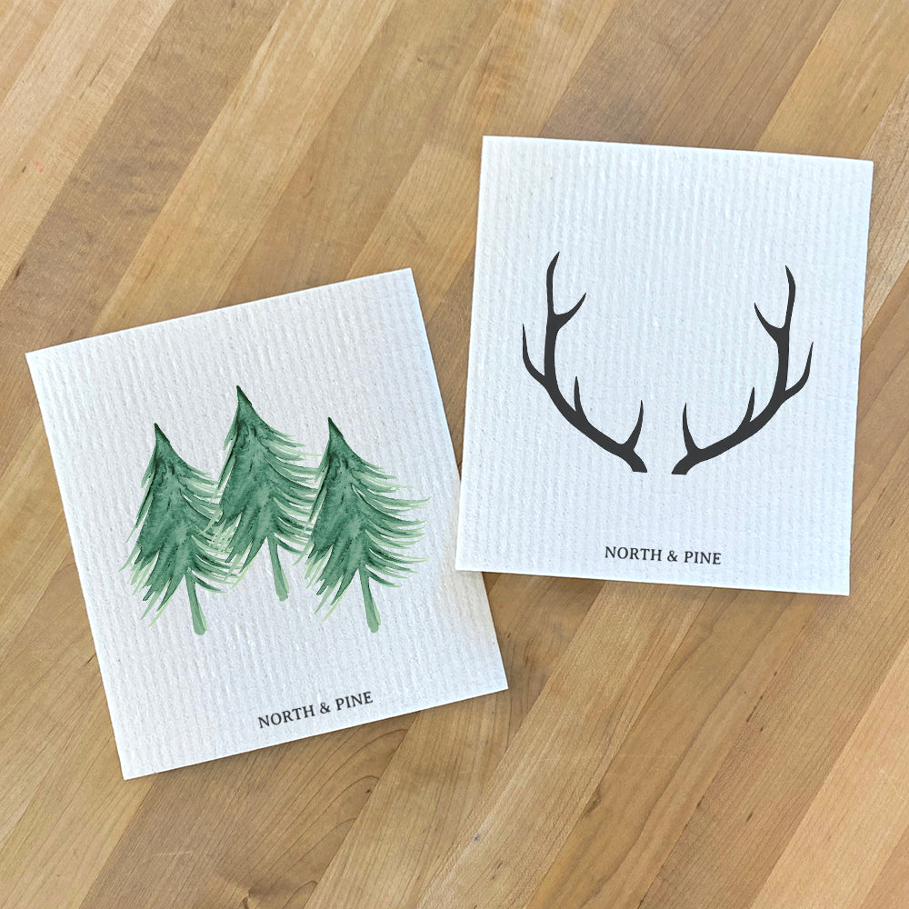 Two Swedish dish cloths featuring Three Trees and Antlers designs, eco-friendly and compostable, perfect for kitchen cleaning.
