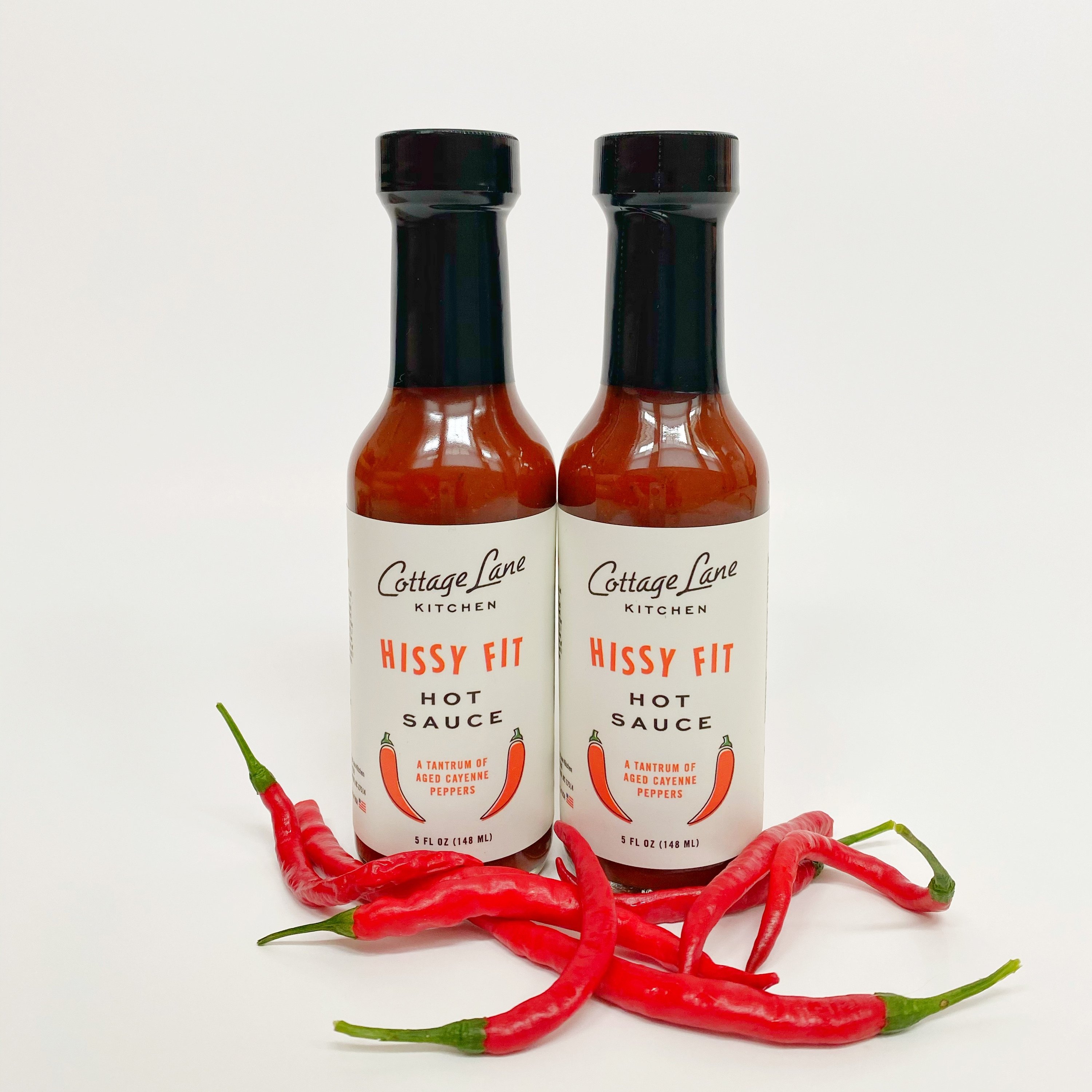 Two 5oz bottles of Hissy Fit Hot Sauce with a vibrant red color, showcasing its spicy appeal.