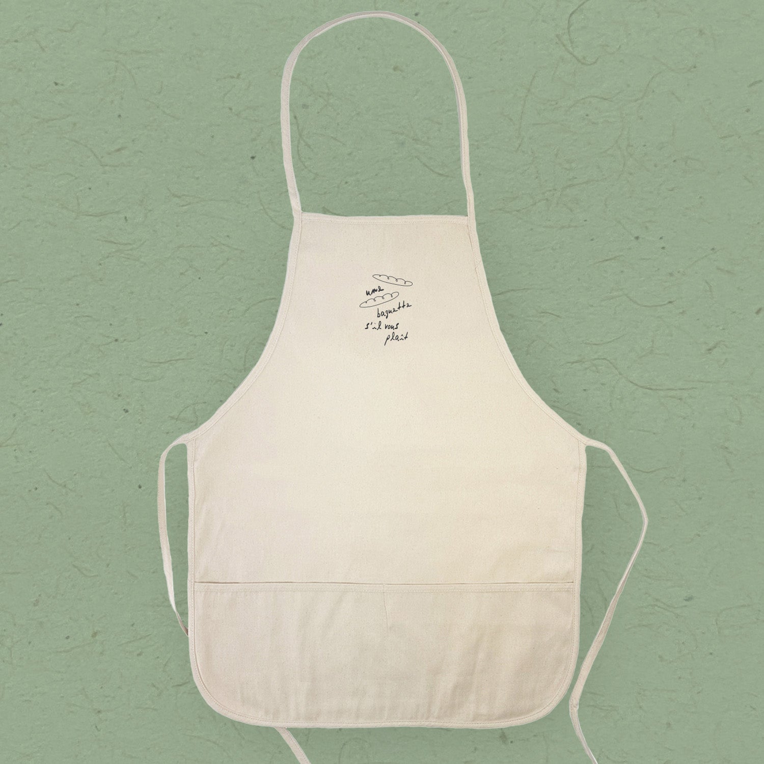 A stylish women's apron made of cotton canvas, featuring natural twill ties and a divided front pocket, perfect for cooking.