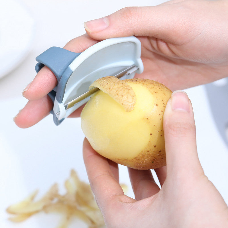A stainless steel vegetable peeler with a finger ring design, showcasing its sharp blade and ergonomic handle for easy peeling.