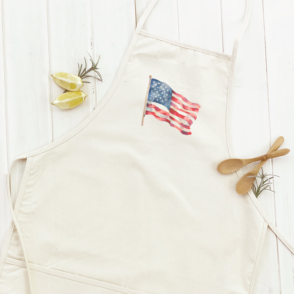 A stylish women's apron featuring a watercolor American flag design, made from durable cotton canvas with adjustable neck and twill ties.