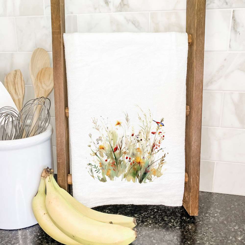 A vibrant cotton tea towel featuring a watercolor design of birds and wildflowers, perfect for kitchen use.