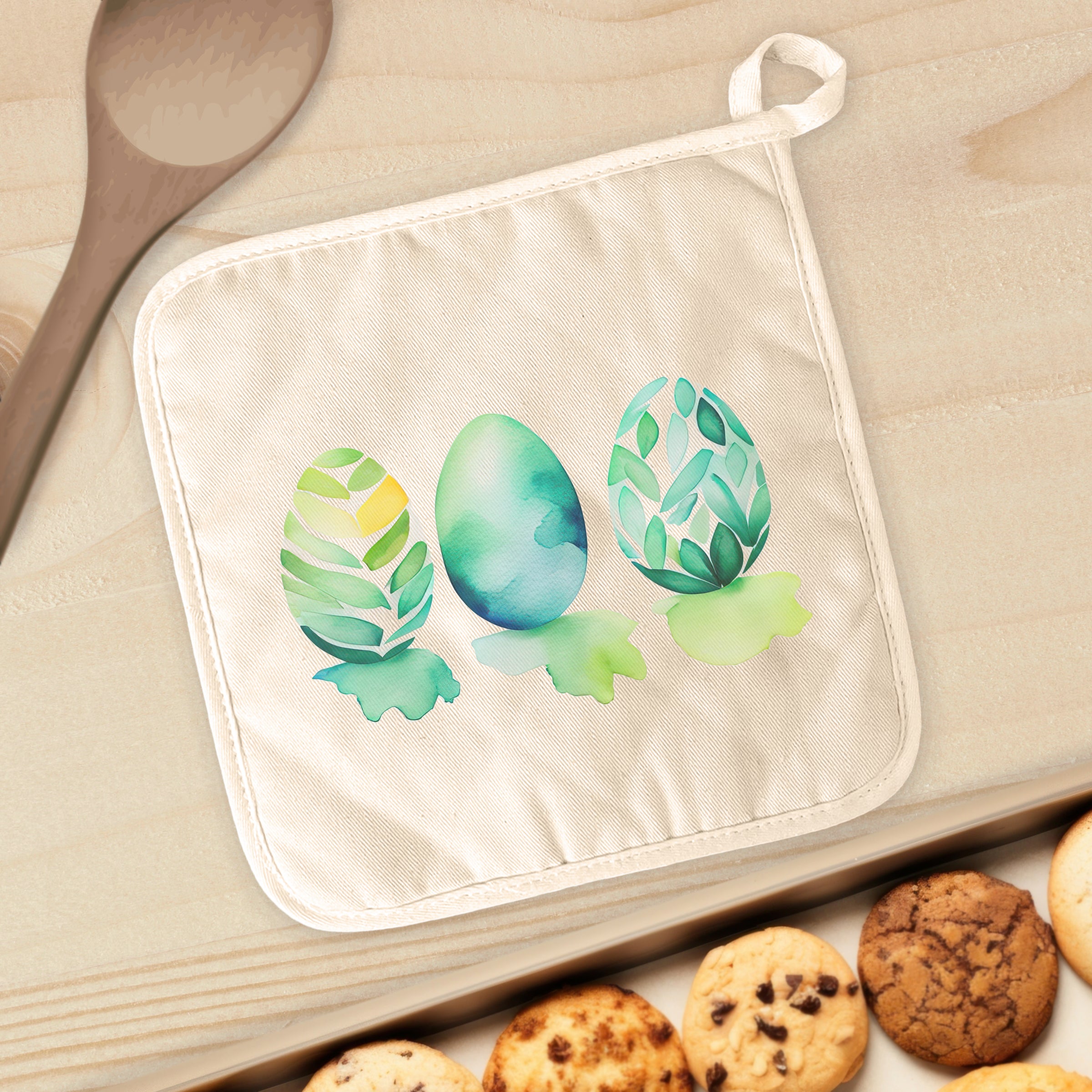 A vibrant watercolor Easter egg design on a cotton pot holder, showcasing its square shape and hanging loop.