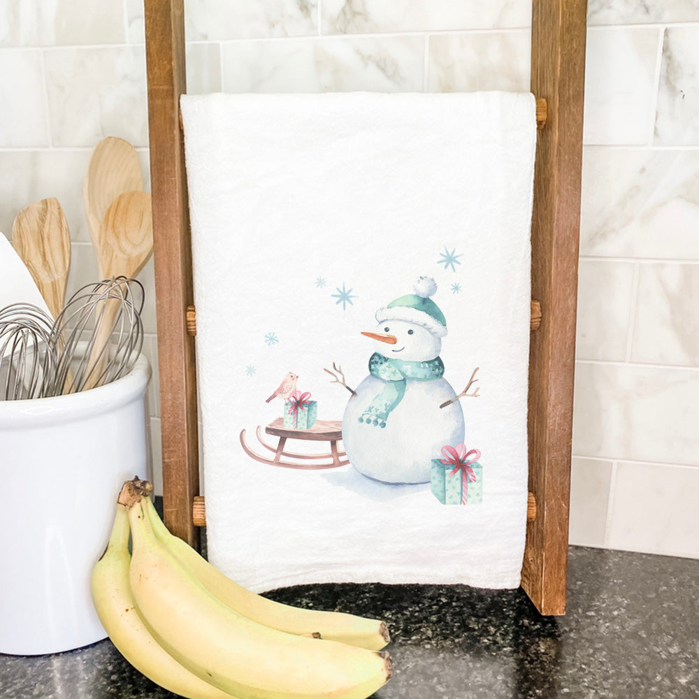 A vibrant watercolor snowman design on a 100% cotton tea towel, perfect for holiday kitchen decor.