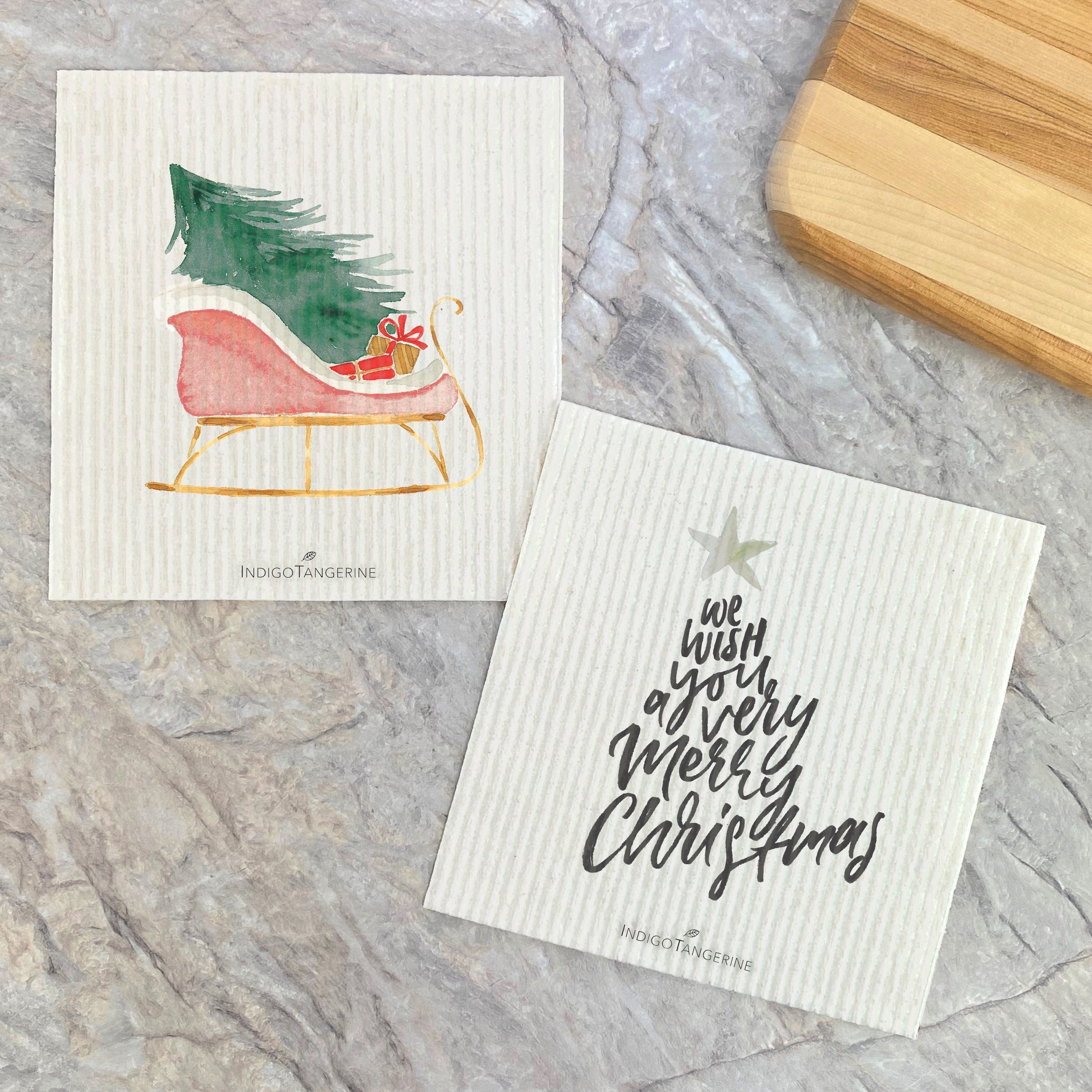 Two Swedish dish cloths featuring a festive Christmas sleigh design, made from eco-friendly materials.