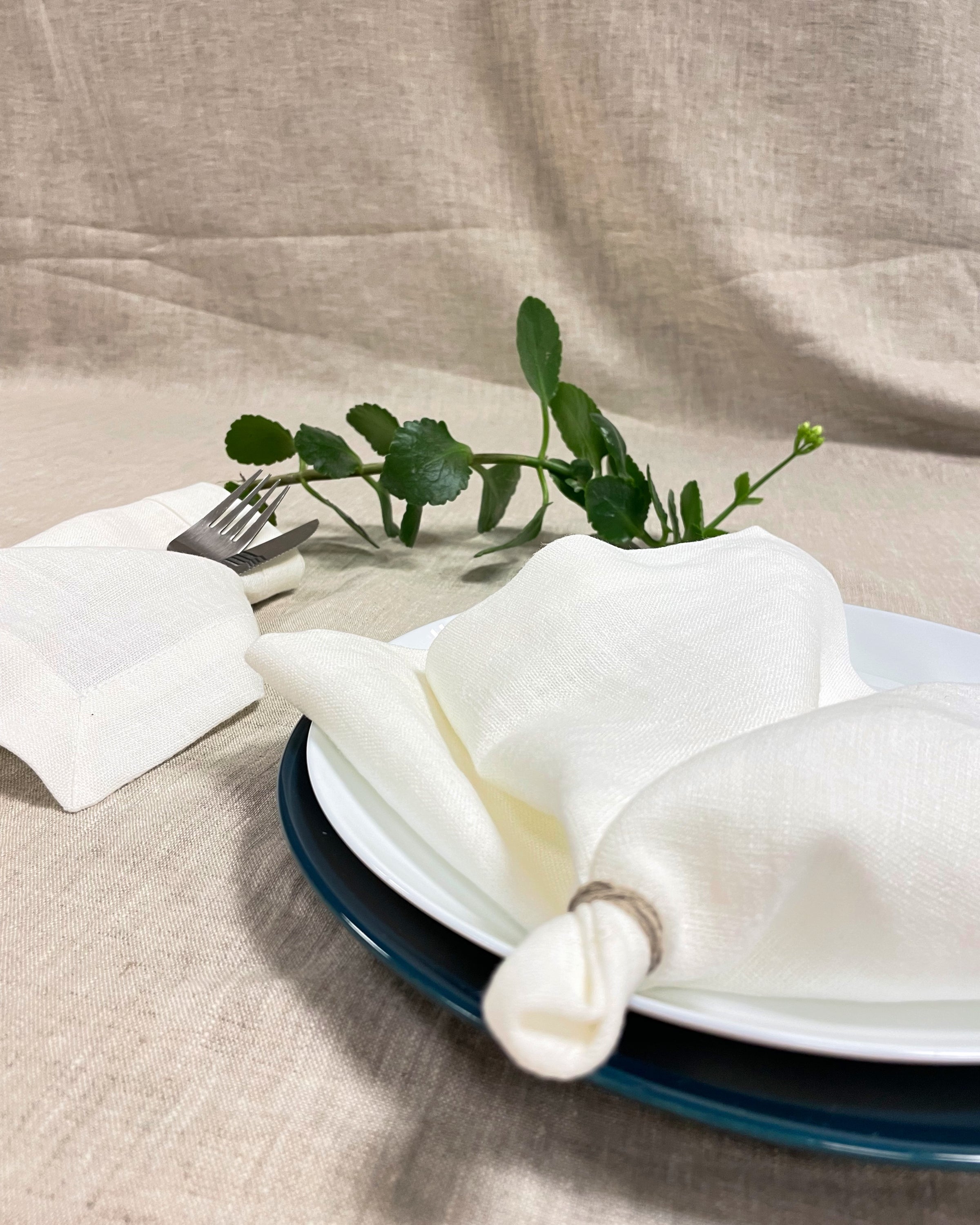 Set of two white linen napkins made from 100% stonewashed linen, featuring a decorative hem and soft texture, perfect for elegant dining.