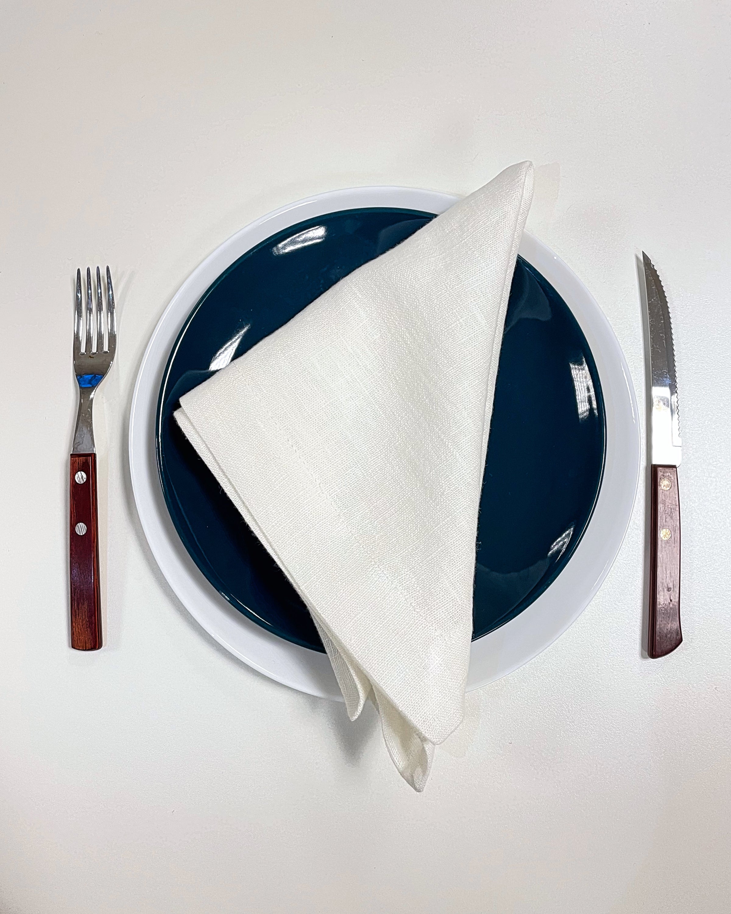 Set of two white linen napkins made from 100% stonewashed linen, featuring a decorative hem and soft texture, perfect for elegant dining.
