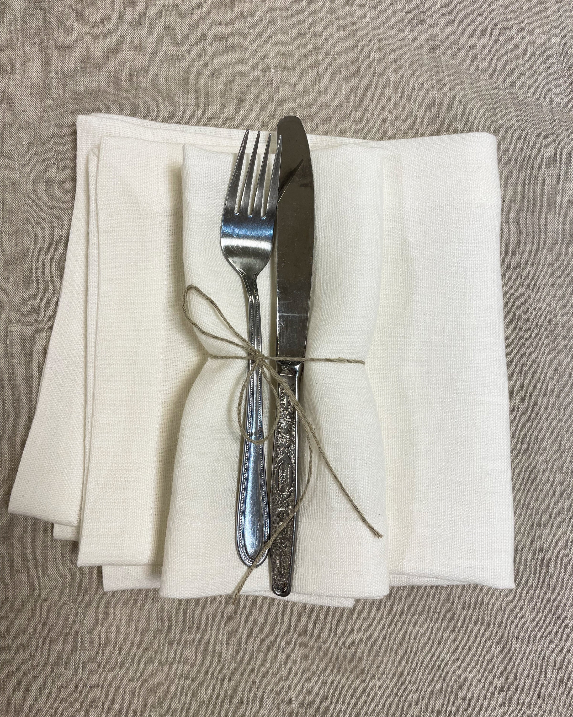 Set of two white linen napkins made from 100% stonewashed linen, featuring a decorative hem and soft texture, perfect for elegant dining.