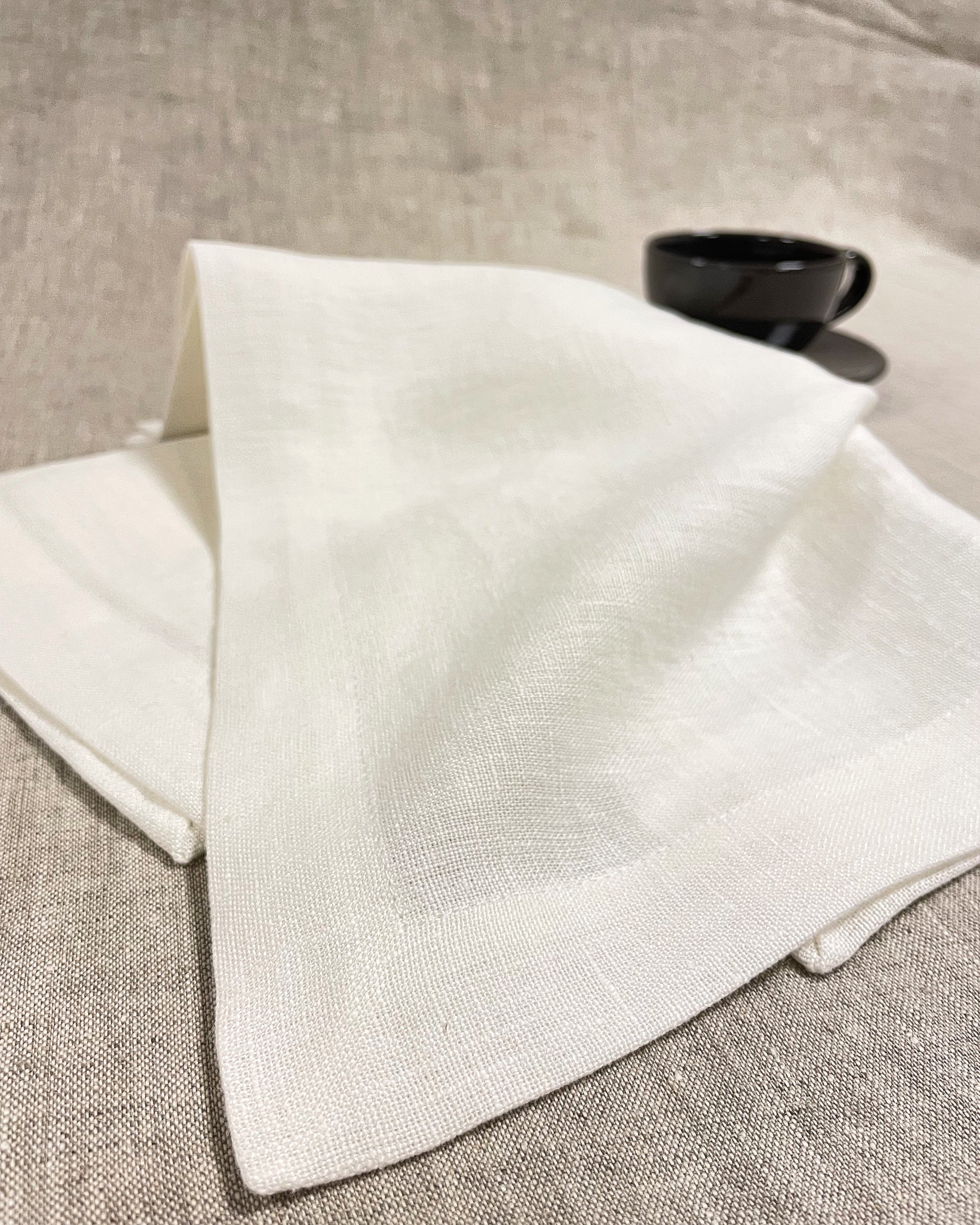 Set of two white linen napkins made from 100% stonewashed linen, featuring a decorative hem and soft texture, perfect for elegant dining.