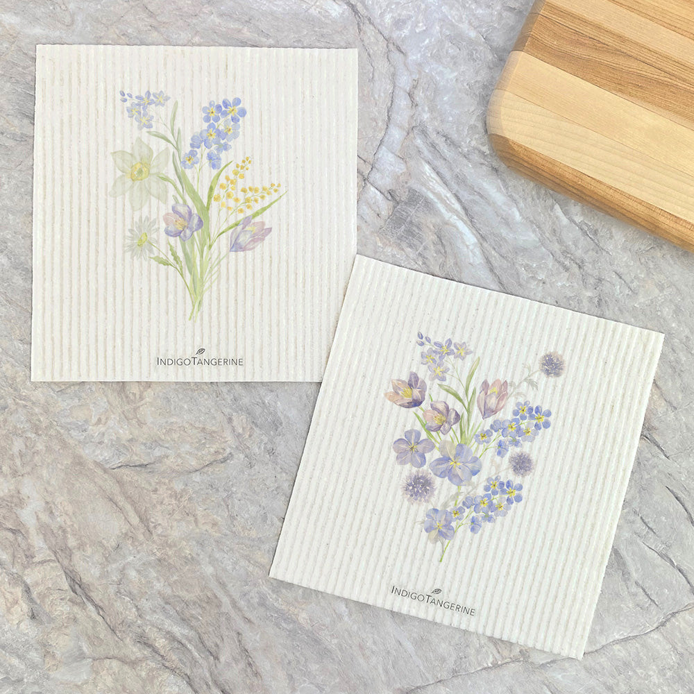 Two eco-friendly Swedish dishcloths featuring a vibrant purple wildflower design, perfect for sustainable cleaning.