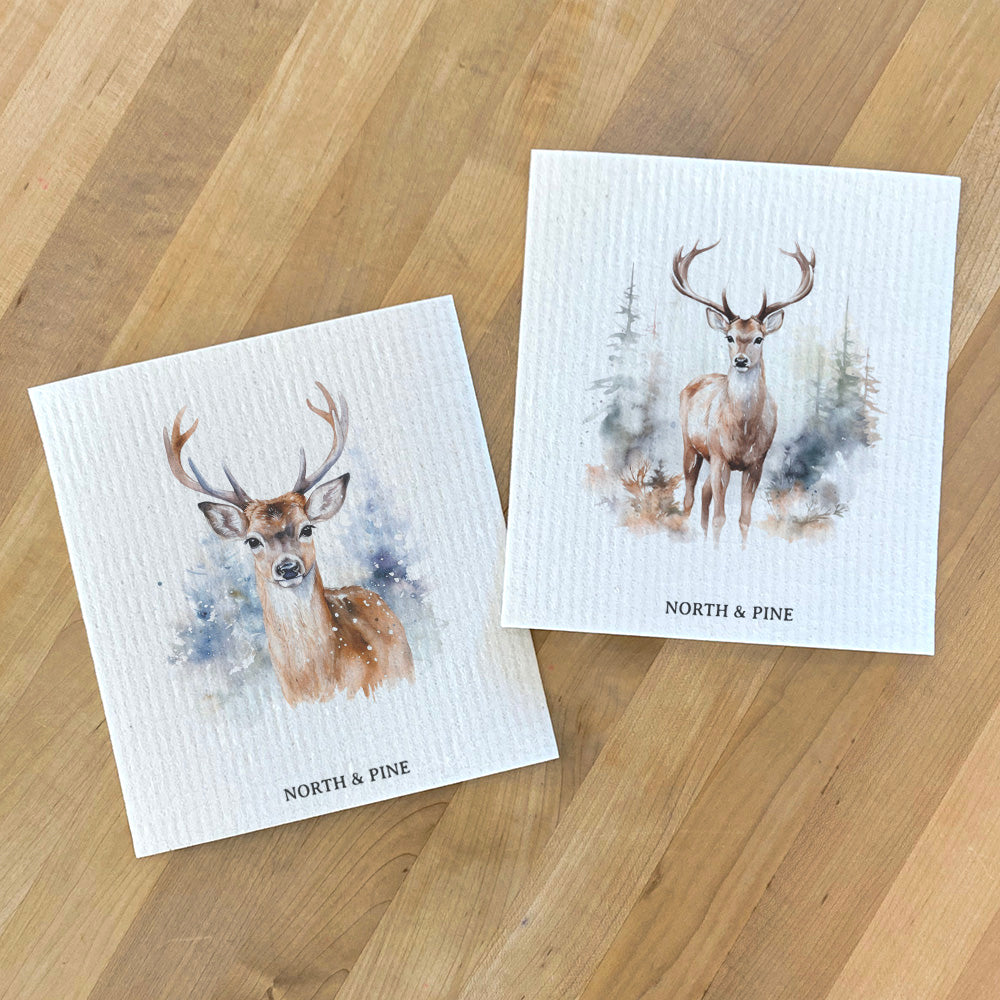 Two eco-friendly Swedish dish cloths with Winter Buck design, made from plant-based fibers.