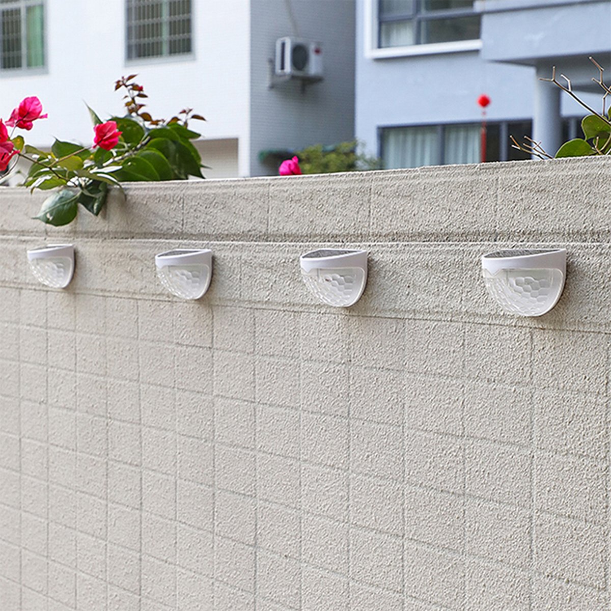 Two solar semicircle wall lights with fish scale design, waterproof and suitable for outdoor use, illuminating a garden area.