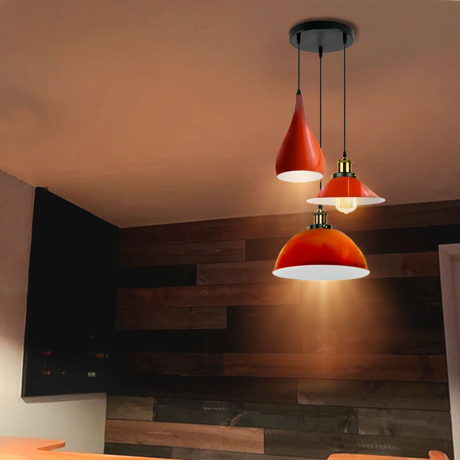 Three head pendant light fixture in orange metal, showcasing a modern design with three light holders and a round ceiling plate.