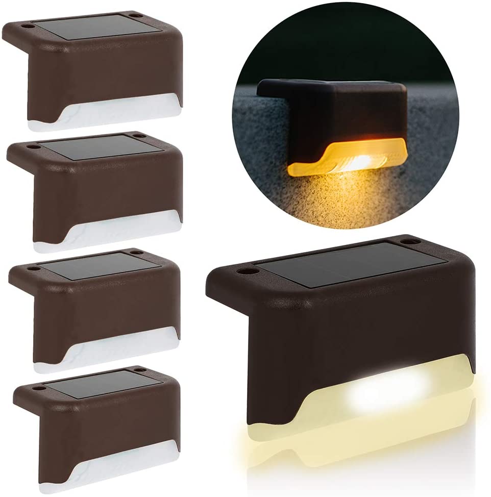 Four solar deck lights installed on a wooden patio, illuminating the pathway with a warm glow, showcasing their waterproof design.