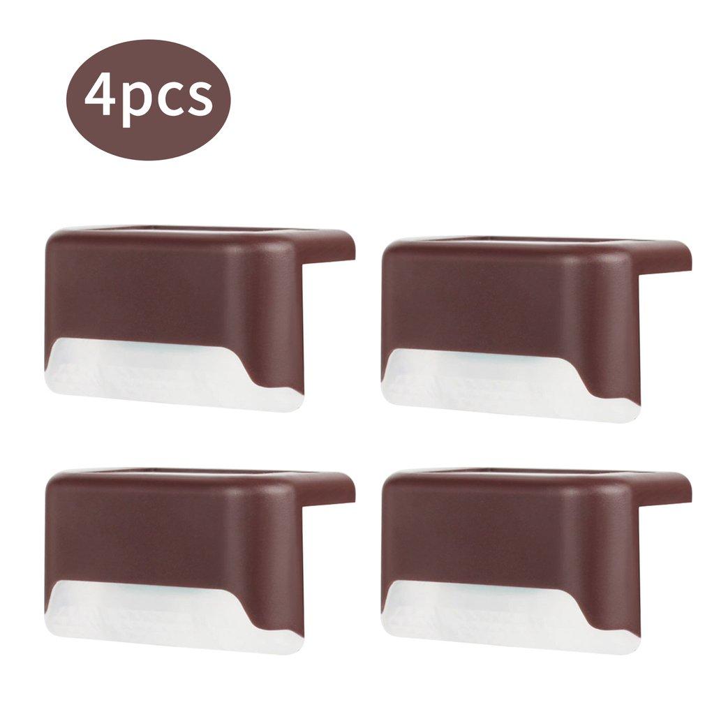 Four solar deck lights installed on a wooden patio, illuminating the pathway with a warm glow, showcasing their waterproof design.