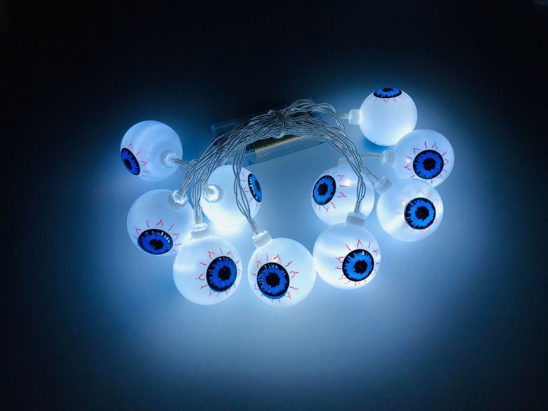 A string of 10 LED eyeball lights, perfect for Halloween decorations, featuring spooky eyeball designs in various colors.