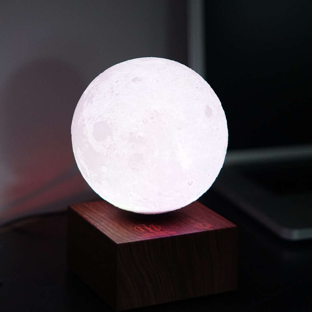 A 6-inch levitating moon lamp showcasing detailed lunar topography, floating above a wooden base with a soft glow.