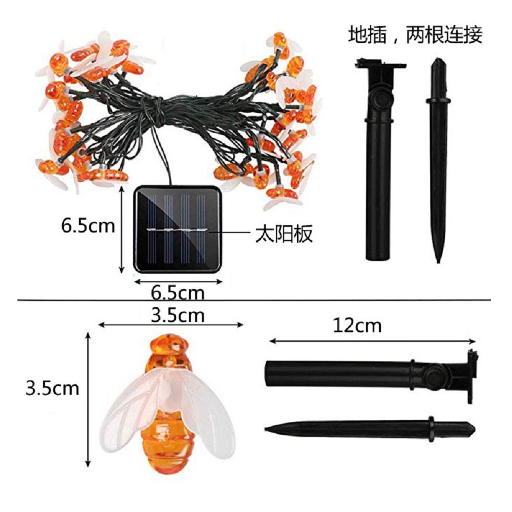 A string of solar-powered LED fairy lights shaped like cute honey bees, illuminating a garden at night.