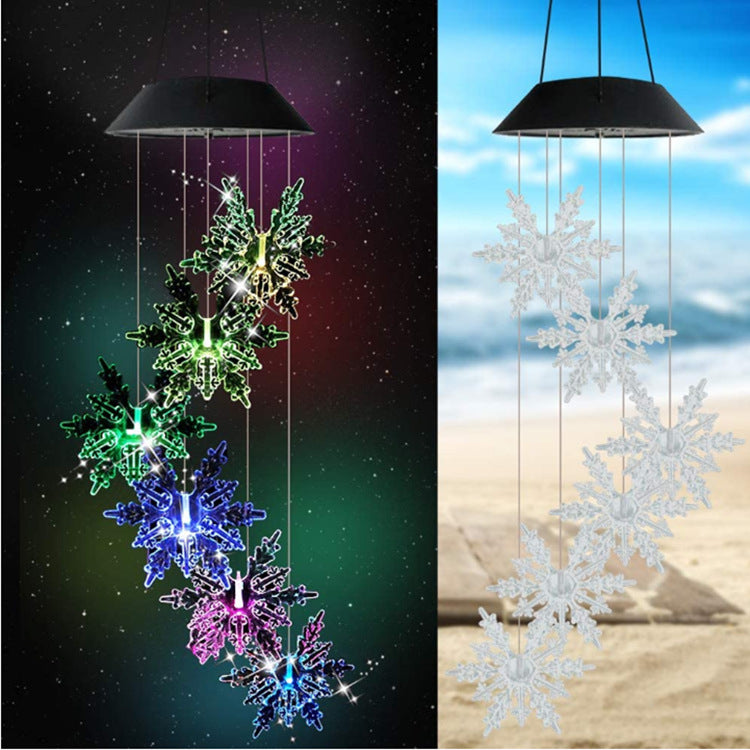 Outdoor Solar Wind Chime Lamp with hummingbird and butterfly designs, glowing softly at night.