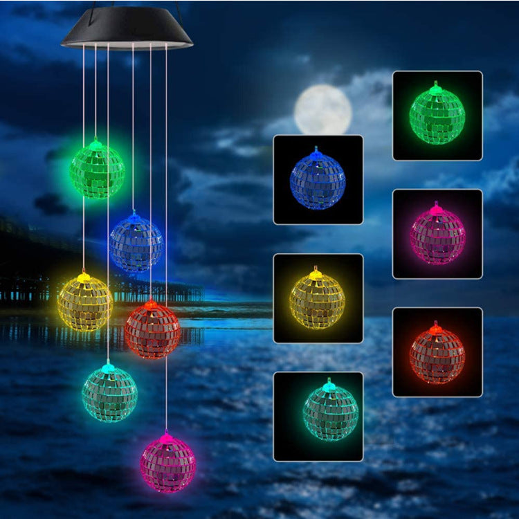 Outdoor Solar Wind Chime Lamp with hummingbird and butterfly designs, glowing softly at night.
